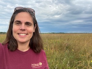 Melissa Ahlering standing in a field under grey sky