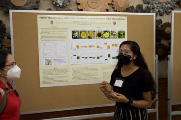 Student stands in front of her project poster